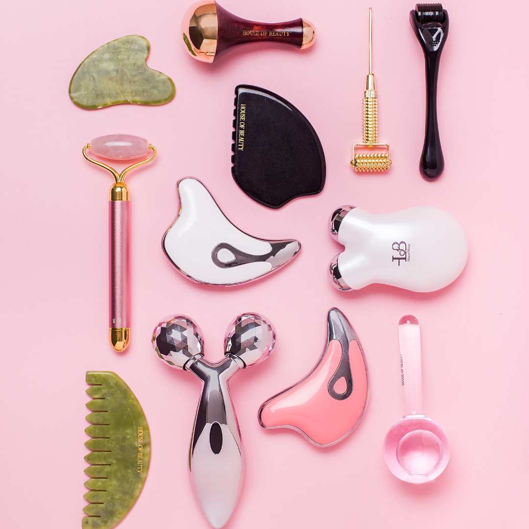 Professional facial massage tools including gua sha for aging, jade roller for skin tightening, face roller, and derma roller for puffiness on pink background at House of Beauty India.