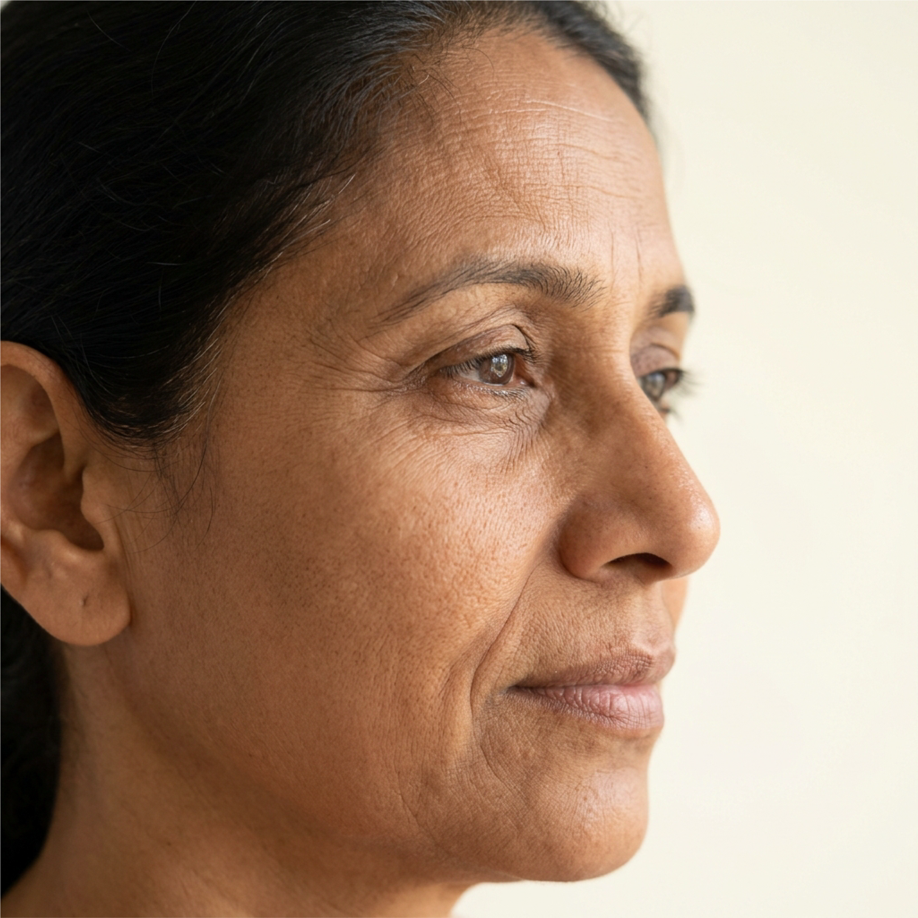 Portrait of a mature woman with visible wrinkles and fine lines around the eyes and face.